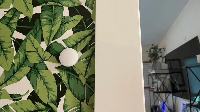 The Cync temperature sensor hangs on a wall