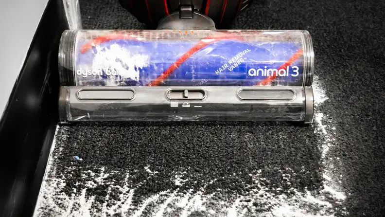 The Dyson Animal 3 cleaning baby powder off of black carpet.