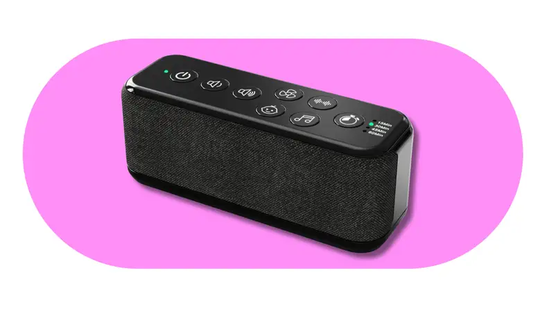 Portable black sound machine with built-in speaker and control buttons on a pink background.