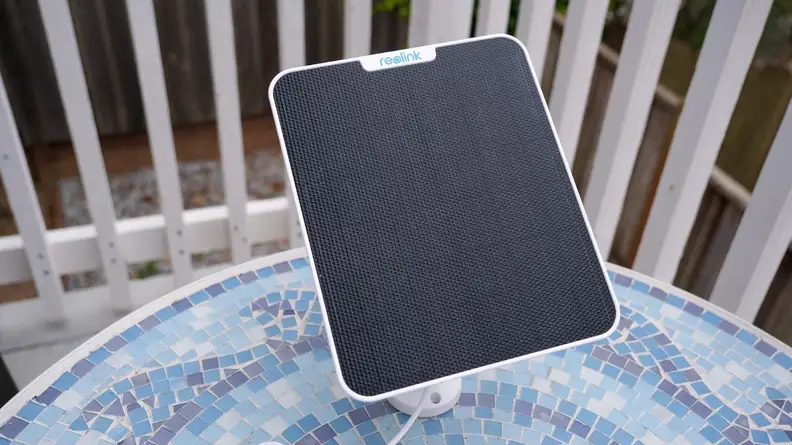 The Reolink solar panel on top of a round table outdoors.