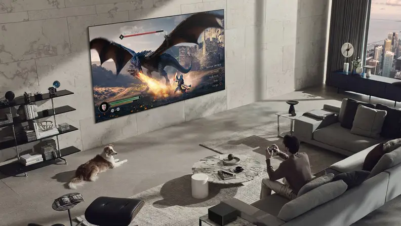 The wireless LG M4 OLED TV mounted onto a wall, displaying a video game to a young person on a couch