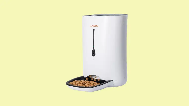 White pet feeder with full food bowl against a yellow background