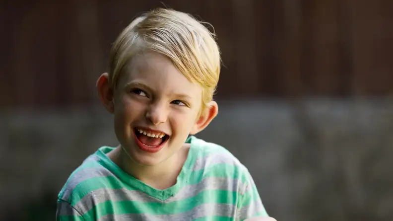 A boy with short hair smiling
