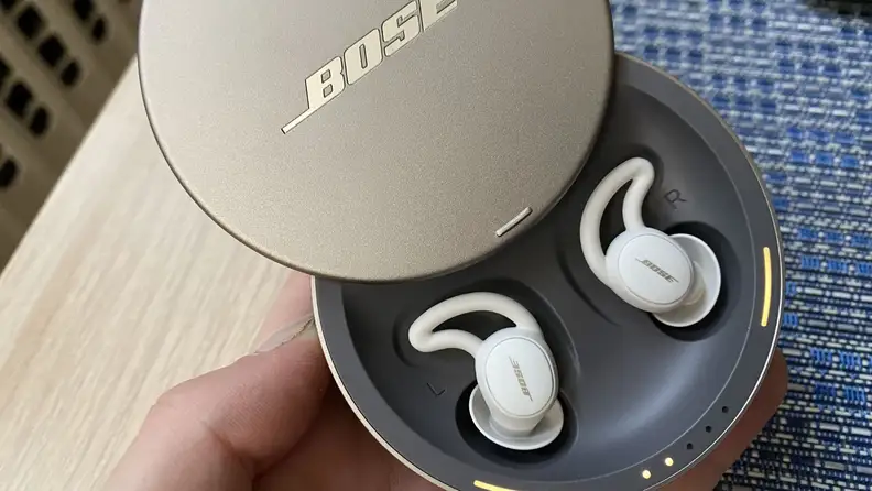 The Bose Sleepbuds II in their circular case with the lid slid open