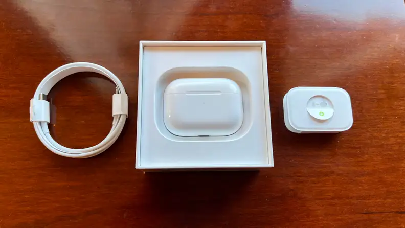 An unpackaging of the Apple AirPods Pro (second gen), featuring charger, case and packaged earbuds.