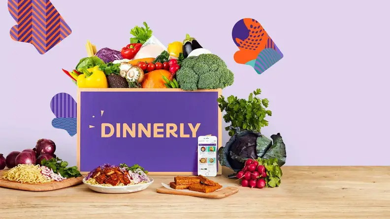 A Dinnerly box with fruits and vegetables popping out of the box.