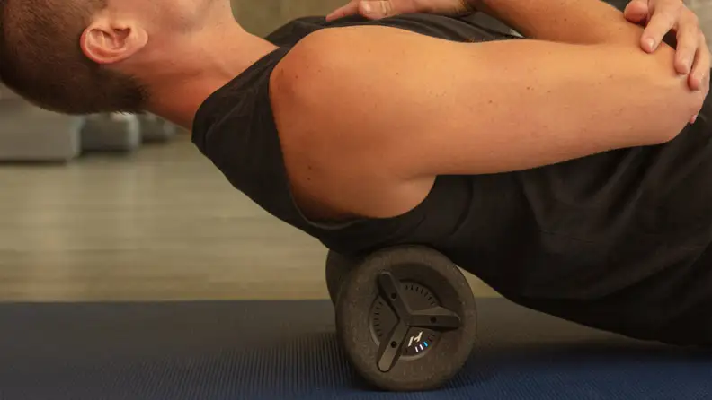 A man rolling his back with the Hyperice Vyper 3.