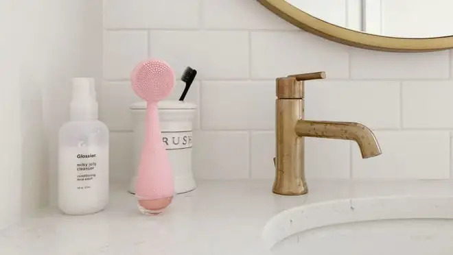 Pink facial cleansing device next on sink counter
