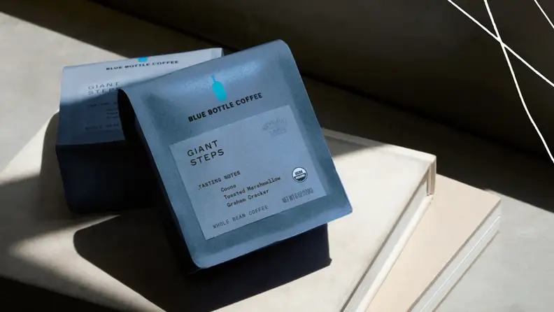 Two Blue Bottle Coffee Giant Steps bags resting in sunlight