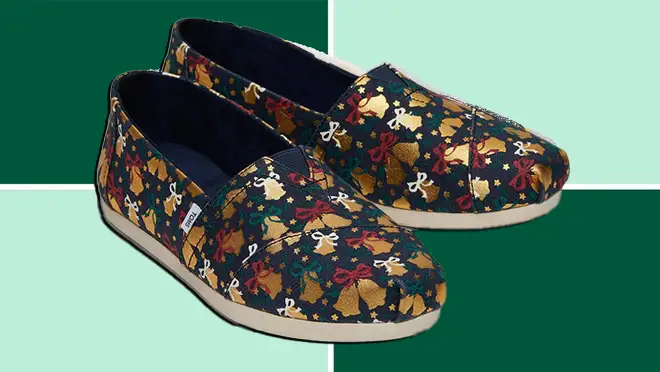 A pair of TOMS Gold Foil Bells shoes on a dark and light green background.