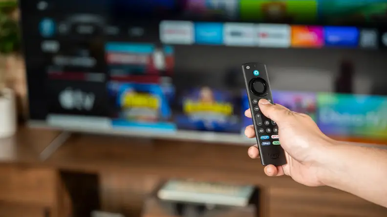 A close-up of someone holding the Amazon Fire TV Omni's remote control