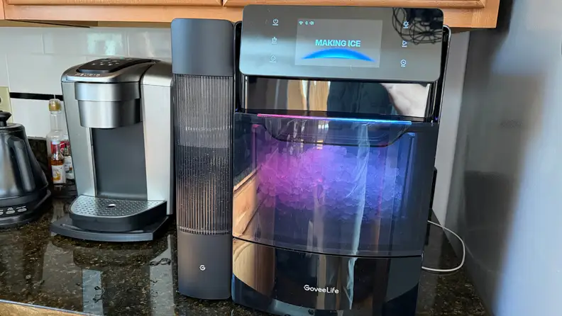 The GoveeLife ice maker on a kitchen counter with purple RGB lighting illuminating the internal ice compartment.