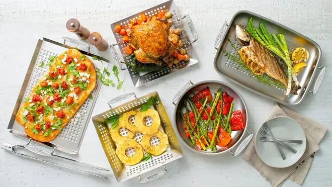 Assorted foods in silver cookware on countertop in kitchen.