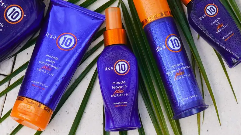 The It's A 10 Keratin line of products laying on top of a palm leaf.