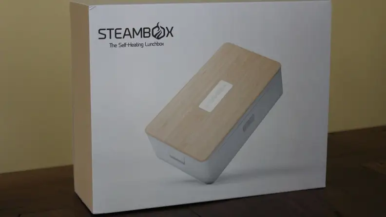 The packaging of the Steambox on a wooden surface