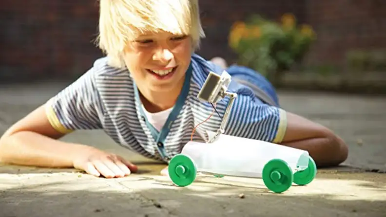 Boy playing with solar robot