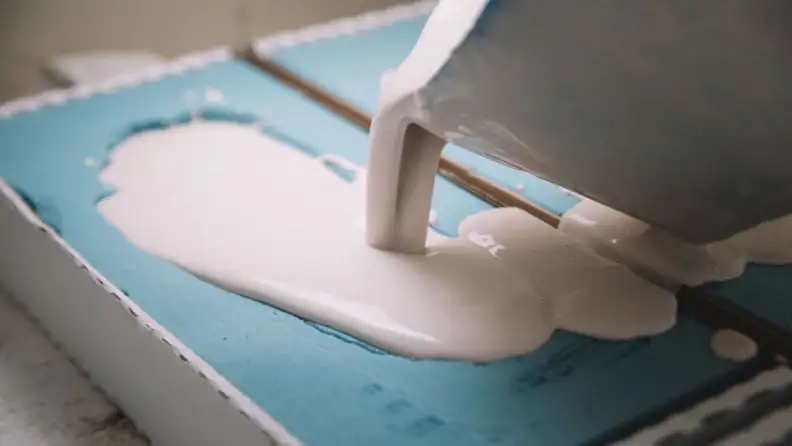 Plaster being poured into light blue mold