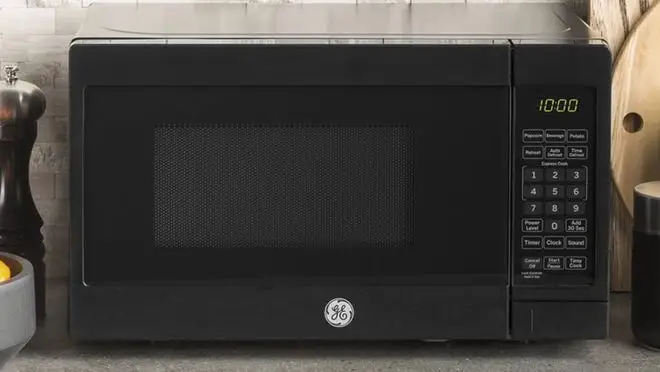 Black microwave on countertop in kitchen.