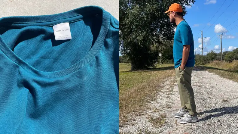 A photo of a teal Amazon Made For You custom T-shirt, showing off its label. A man standing to the side in his Amazon T-shirt.