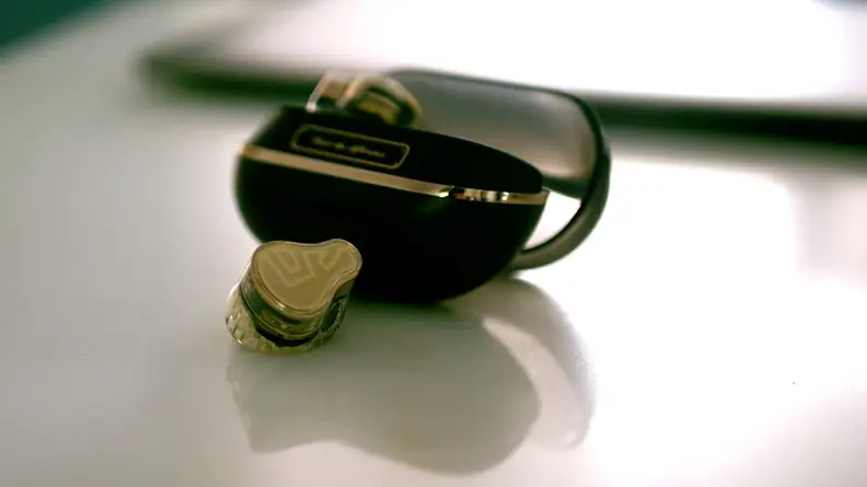 A single earbud next to its case