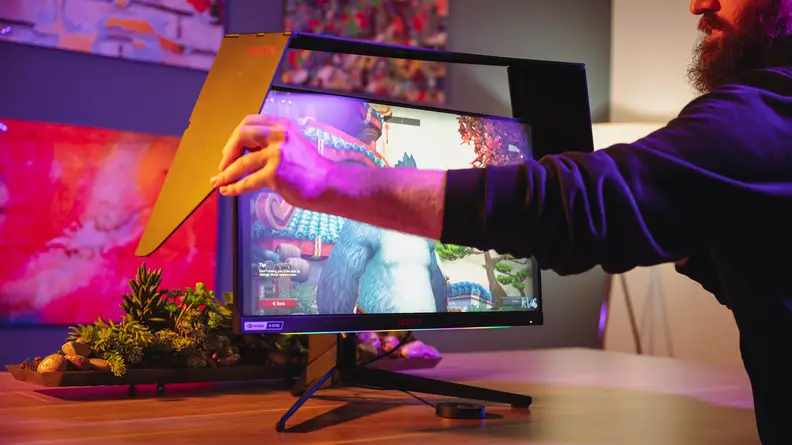 A person putting attached a monitor hood to a monitor
