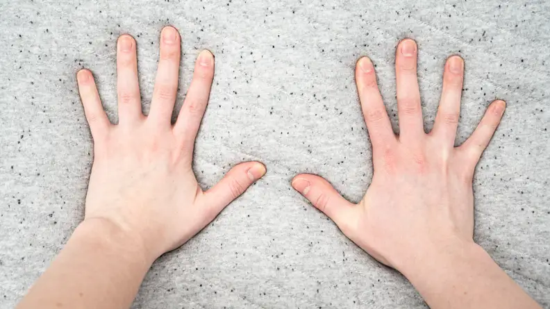 a woman's hands press into a foam mattress