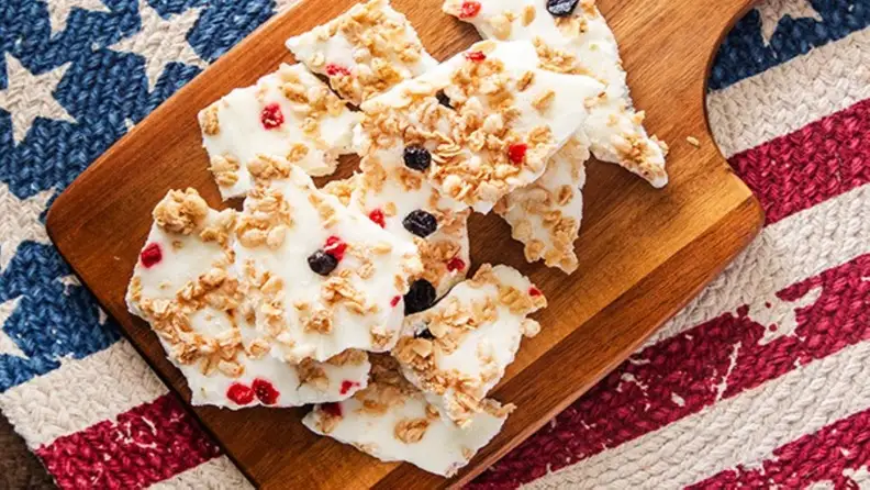 Yogurt bark with granola and berries on a cutting board