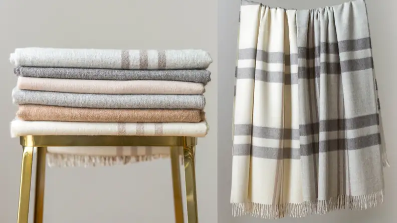 Left: Stack of folded blankets on stool; Right: Two wool blankets hanging up