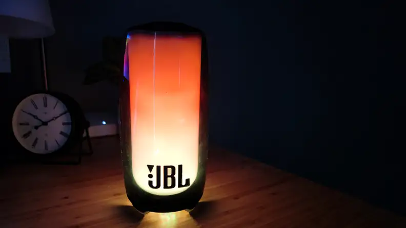 The JBL Pulse 5 shown playing a lava lamp effect in a dark room.