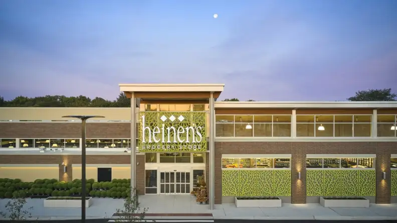 Heinen's storefront exterior at dusk with illuminated signage