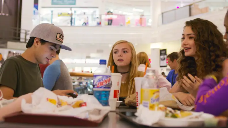 Elsie Fisher, teenage star of Bo Burnham’s Eighth Grade, sits with a group of schoolmates in the food court of a shopping mall.