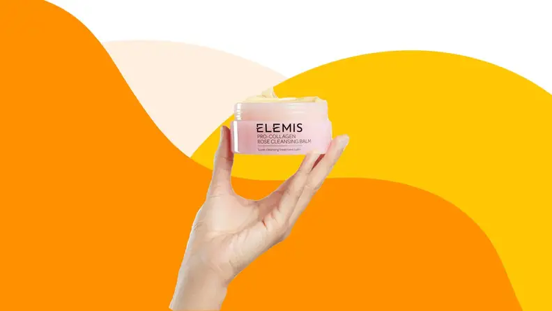 Hand holding up jar of Elemis face cream.