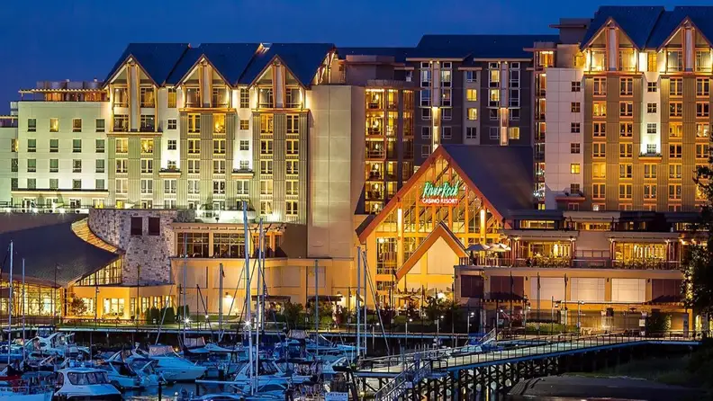 Exterior view of a casino resort by the river full of yachts