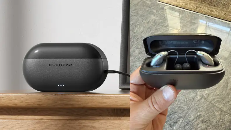 Elehear charging case on a light wooden table, next to a hand holding an open charging case showing the hearing aids