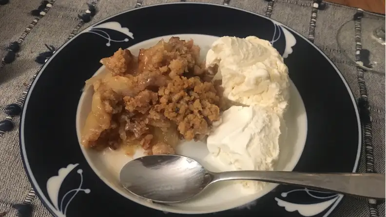 Piece of apple crisp with vanilla ice cream