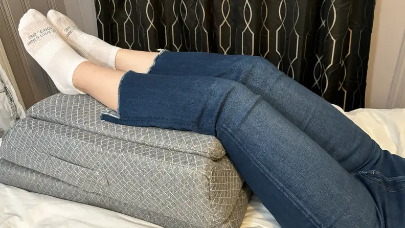 A tester rets the KingPavonini pillow behind her knee