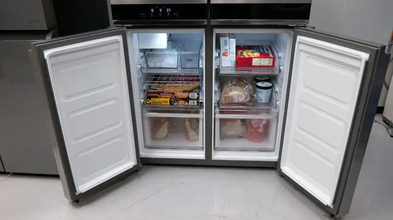 A close-up of the Whirlpool WRQA59CNKZ's two freezer compartments. Each compartment's door is open, showcasing their fully-stocked interiors.