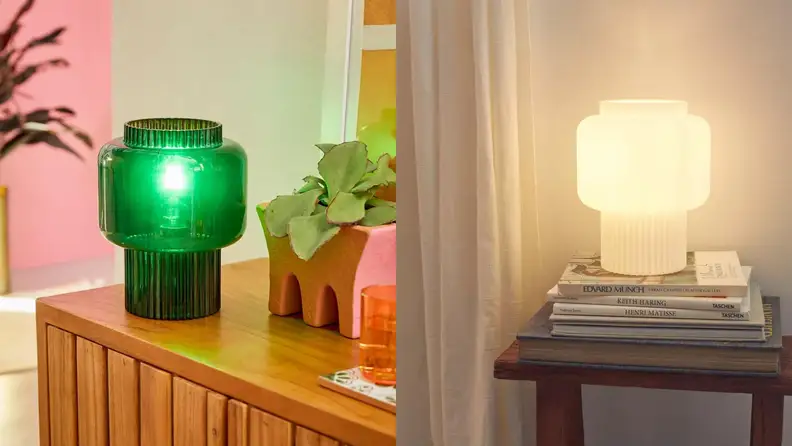 A glass lamp in emerald green on a natural wood dresser. On the right, the same lamp in white glass.