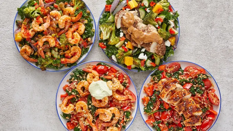 A photo of four healthy Blue Apron wellness dishes shot from above on white-gray background.