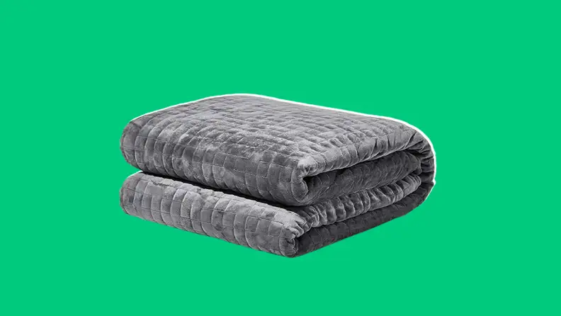 Grey gravity weighted blanket on a dark green background