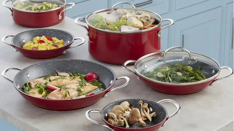 Red cookware on countertop with food in it