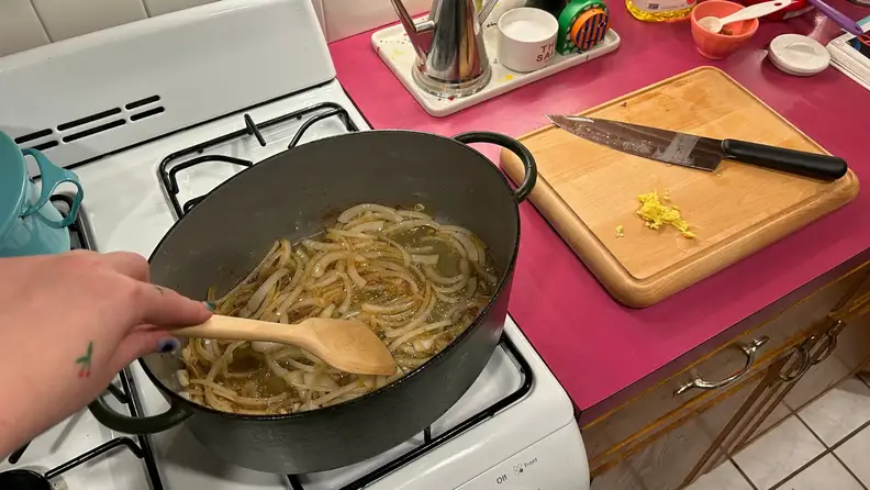 Pasta getting cooked in a kitchen with the Caraway prepware spread out.
