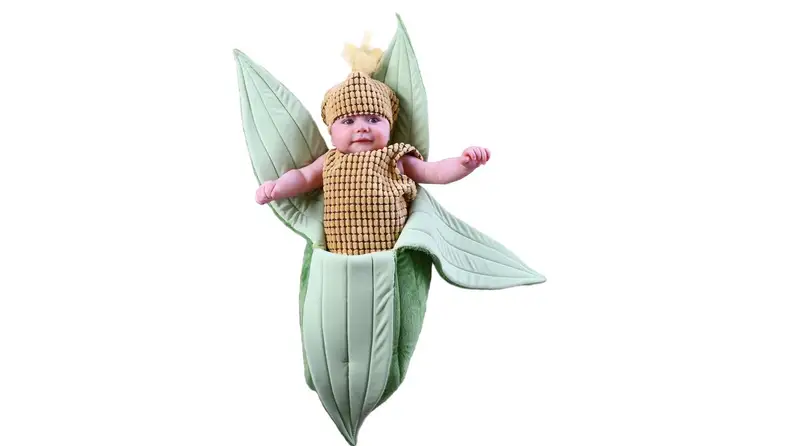 A baby dressed in a corn husk Halloween costume.