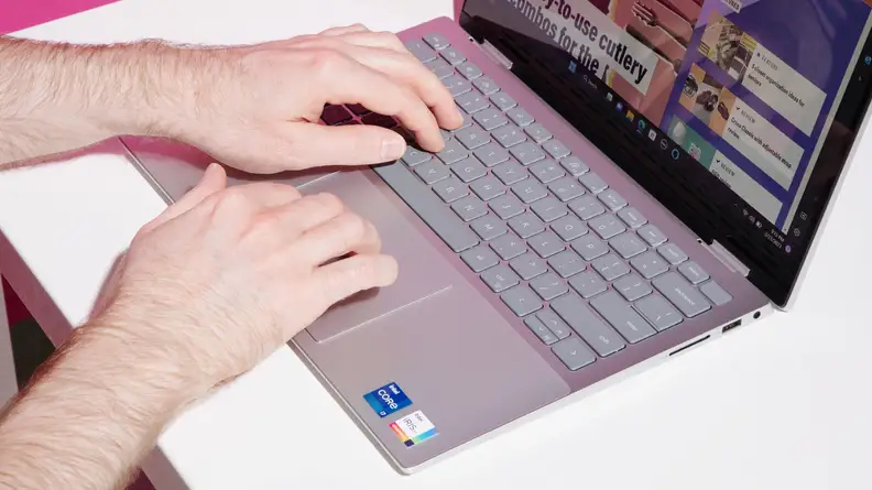 A person's hands graze the keyboard of the Dell Inspiron 14 7420.