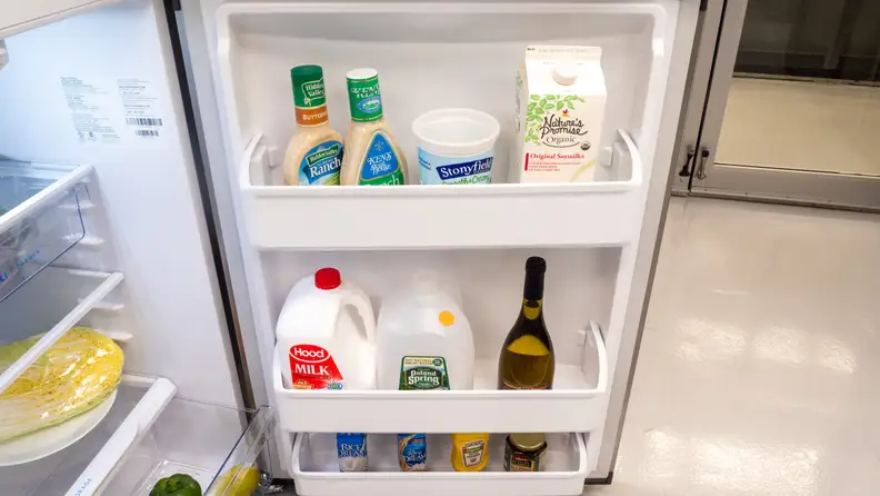 The door of the Frigidaire FFHT1425VV is opened wide, its three shelves stocked with groceries.