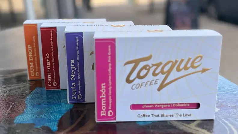 Four coffee boxes with flavor labels displayed on a table