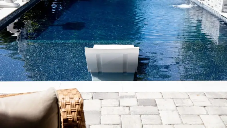 Pool corner with white in-water bench seat and water feature