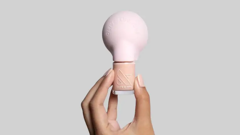 A hand holding up the Poppy nail polish.