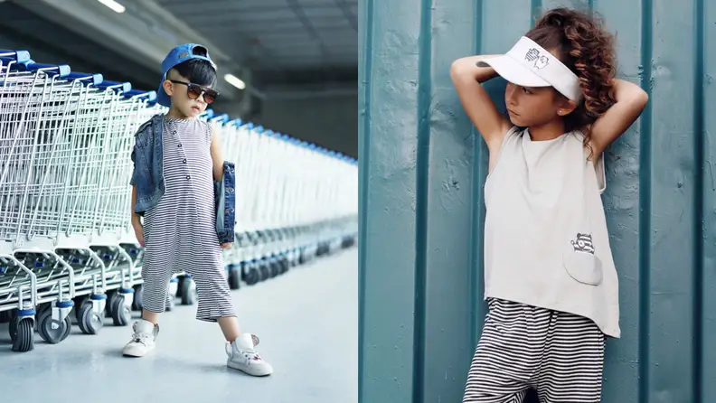 Left: small Asian toddler boy wearing a cool looking onesie next to a bunch of shopping carts. He's wearing a backwards cap, sunglasses, jean jacket, and cool sneakers. Right: a Black toddler girl is wearing an asymmetrically cut tank top with a pocket on the lower right side and striped pants. She has her hands behind her head, looking to the right, leaning up against a wall with a white visor on her brown natural hair