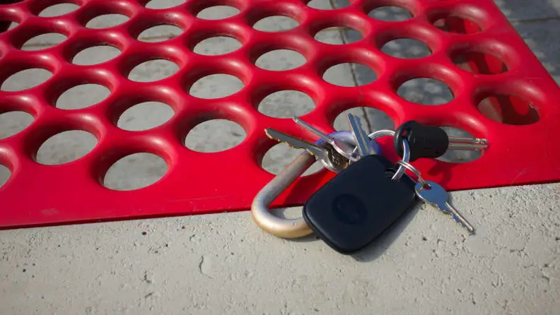 Tile's Pro tracker, attached to a set of keys, laying atop a bus stop bench.